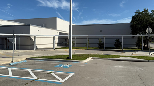 Tampa Florida, Progress Village Middle School's parking lot with a handicap spot and a covered sidewalk leading to the entrance.